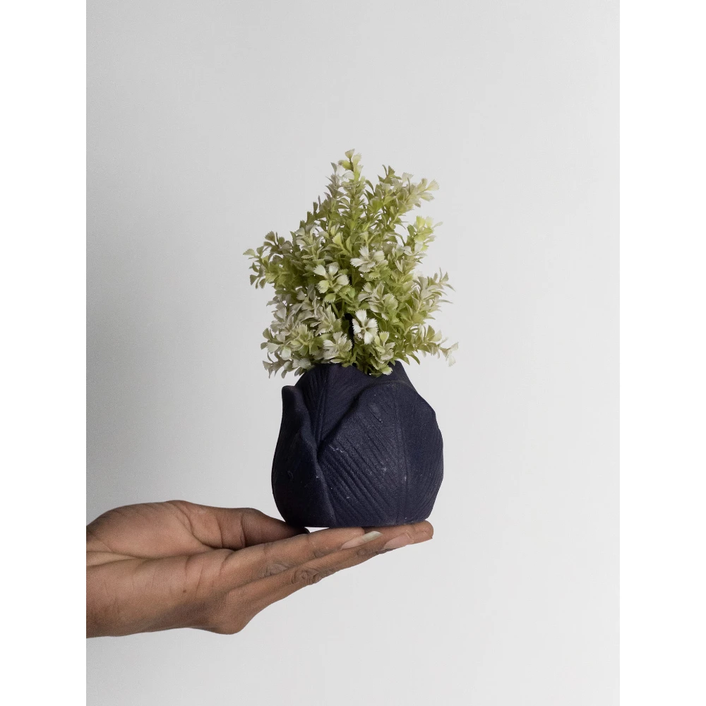 The Midnight Fold Mini Planter is a refined ceramic piece designed for lovers of minimal yet artistic décor. Featuring a softly rounded silhouette with subtle folded texture detailing, this planter creates a sophisticated sculptural presence despite its compact size. The rich midnight blue matte finish adds depth and modern elegance, making it perfect for contemporary interiors. Its organic folded pattern gives it a handcrafted aesthetic while maintaining a clean, minimal appeal. Midnight Fold Mini Planter